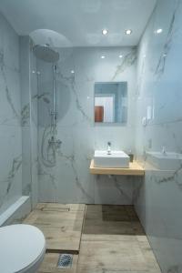 a white bathroom with a sink and a shower at Bellisimo studios in Zakynthos