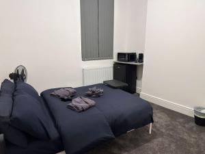 Un dormitorio con una cama azul con toallas. en Modern Central London Room Zone1, en Londres