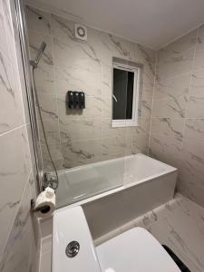a bathroom with a tub and a toilet and a sink at Modern Central London Room Zone1 in London