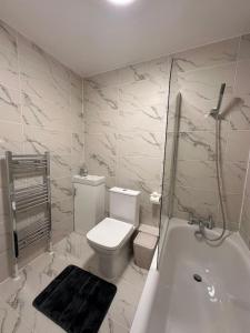 a bathroom with a toilet and a shower and a tub at Modern Central London Room Zone1 in London