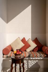 - un canapé avec des oreillers et une table avec des fruits dans l'établissement Sofitel Bahrain Zallaq Thalassa Sea & Spa, à Manama