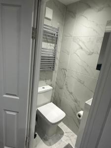 baño con aseo blanco y paredes de mármol en London Bridge 15 minutes away en Londres