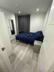 a bedroom with a blue bed and a wooden floor at London Eye 10 minutes away in London