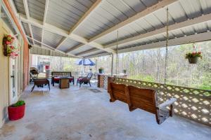 a screened porch with a swing and a table at Seneca Abode with Furnished Deck Less Than 10 Mi to Clemson! in Seneca