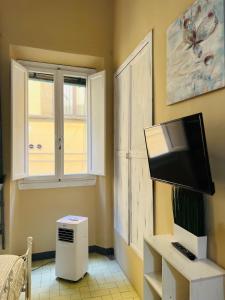 ein Wohnzimmer mit einem TV und einem Fenster in der Unterkunft Signoria studio apartment in Florenz