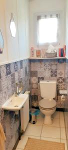 uma casa de banho com um WC e um lavatório em Charmante maison néo-bretonne em Plumaudan