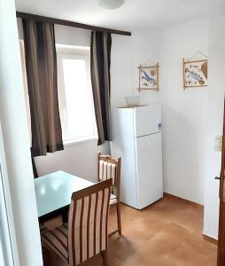 una pequeña cocina con mesa y nevera en One bedroom apartement with balcony and wifi at Vir, en Vir