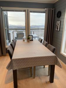 een eettafel met stoelen en een groot raam bij Cabin - Målselv fjellandsby in Bergset