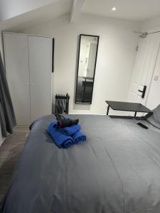 - un lit avec une couverture bleue et un miroir dans l'établissement London Eye,Big Ben 10 mins away, à Londres