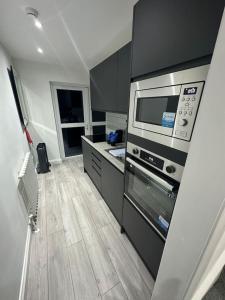 une cuisine avec une cuisinière et un micro-ondes dans l'établissement London Eye,Big Ben 10 mins away, à Londres