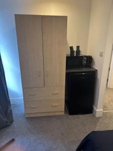 a bedroom with a dresser and a cabinet with a microwave at Buckingham Palace 15minutes away in London