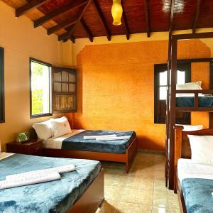 een slaapkamer met 2 bedden en een stapelbed bij hotel villa nazareth in Quimbaya