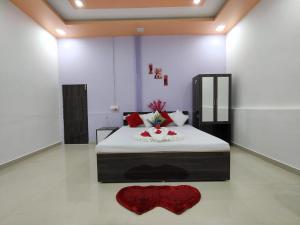 een slaapkamer met een groot bed en een rood tapijt bij NANDAN RESORT 