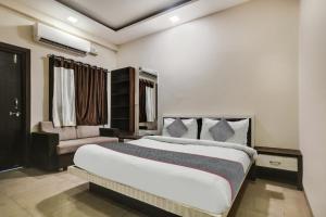 インドールにあるSuper Townhouse1306 Hotel Prime Stayのベッドルーム(大型ベッド1台、ソファ付)