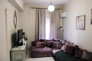 een woonkamer met een paarse bank voor een raam bij Lucato apartment in Florina