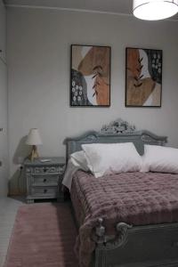 1 dormitorio con 1 cama, mesita de noche y 3 fotografías en Lucato apartment, en Florina