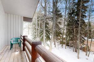 a blue chair sitting on a porch in the snow at All-Season Chalet in Park City