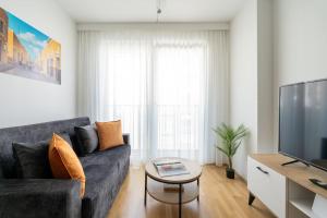 ein Wohnzimmer mit einem Sofa und einem TV in der Unterkunft HM • Urban 1BR Retreat, Easy City Link in Wien