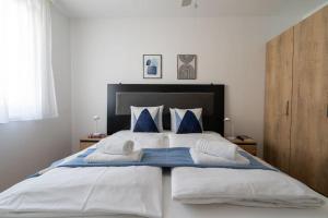 ein Schlafzimmer mit einem großen weißen Bett mit blauen Kissen in der Unterkunft HM • Urban 1BR Retreat, Easy City Link in Wien