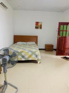 1 dormitorio con 1 cama y ventilador en el suelo en Meenatchi illam, en Trincomalee