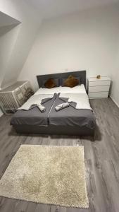 - une chambre avec un grand lit et des chaussons dans l'établissement Reviv - Traumhaftes 3 Zimmer Apartment, à Brühl