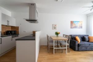 eine Küche und ein Wohnzimmer mit einem Tisch und einem Sofa in der Unterkunft HM • Urban 1BR Retreat, Easy City Link in Wien