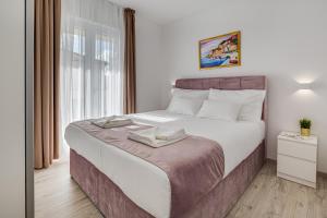 um quarto com uma cama grande e uma janela em Villa Corcovado II em Vodice