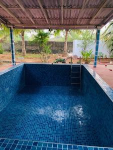 una piscina con suelo de baldosa azul y techo en Meenatchi illam, en Trincomalee