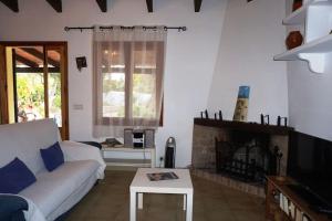 a living room with a couch and a fireplace at Cozy cottage with private pool , BBQ & Free Wifi in Pollença