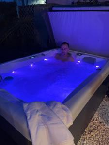 a man in a jacuzzi tub at night at Villa Noa jacuzzi & sauna in Izola