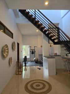 a living room with a staircase and a rug at Ocean Wave Lombok - 4 BR infinity pool villa in Selong Belanak