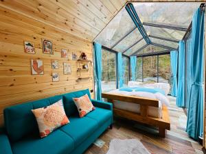 a living room with a blue couch and a bed at River Land Rize in Ayder Yaylasi