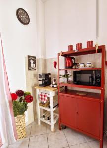 una cucina con mobile rosso e forno a microonde di Casa Imma a Napoli