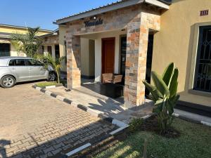 a house with a car parked in front of it at Kumwitu Luxury Apartments in Lusaka