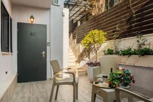een patio met stoelen, een tafel en een deur bij city center apartment in Jeruzalem