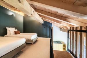 2 Betten in einem Zimmer mit grünen Wänden und Holzdecken in der Unterkunft Chalet Nelcote Morzine - by EMERALD STAY in Morzine