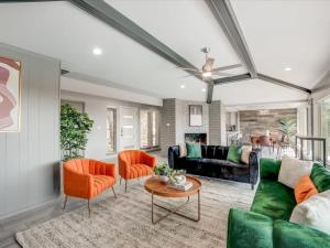 ロックウォールにあるThe Alamo Abode - Lake View Pool Newly Renovatedのリビングルーム(緑のソファ、オレンジの椅子付)