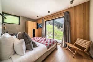 ein Schlafzimmer mit einem Bett und einem großen Fenster in der Unterkunft Chalet Nelcote Morzine - by EMERALD STAY in Morzine