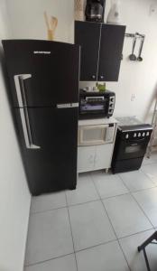 a kitchen with a black refrigerator in a room at Apartamento exclusivo, próximo a UFMS in Campo Grande