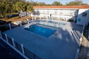 a large swimming pool in front of a building at Impeccably cozy hotel room Developer Inn Express in Kissimmee