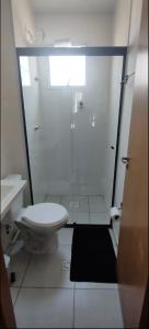 a white bathroom with a toilet and a shower at Apartamento exclusivo, próximo a UFMS in Campo Grande