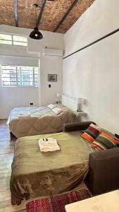 a room with two beds and a couch in it at Monoambiente estudio impecable in Buenos Aires