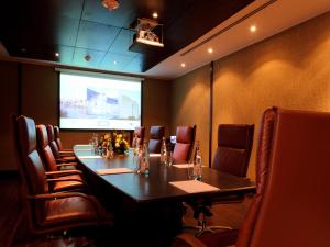 a conference room with a long table and a projection screen at NOI Vitacura in Santiago
