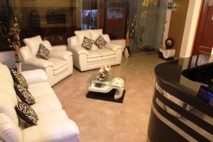ein Wohnzimmer mit weißen Sofas und einem Tisch in der Unterkunft Hotel Conquistador in Andahuaylas