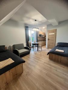 een slaapkamer met 2 bedden en een woonkamer bij Apartamenty Na Rozstaju in Kluszkowce