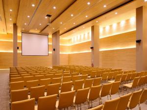 an empty lecture hall with a screen and chairs at NOI Vitacura in Santiago