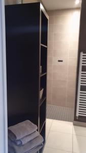 y baño con ducha a ras de suelo y toallas. en B&B Soissons L'Arthome chambres d'hôtes 