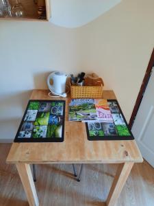 una mesa de madera con revistas encima. en Biert La Coume 2 persoonsbed, en Biert