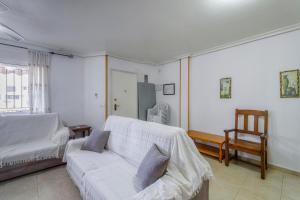 - un salon avec un canapé blanc et une chaise dans l'établissement Adosado Los Alcazares Rio Esla, à Los Alcázares