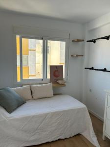 - une chambre blanche avec un lit et une fenêtre dans l'établissement Apartamento 2 habitaciones, à Torre del Mar